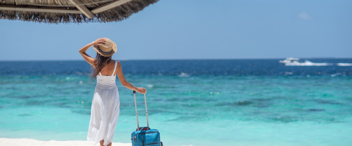 Frau steht am Strand, verlinkt zum Blogbeitrag Reiseversicherungen - Schutz für einen sorglosen Urlaub!